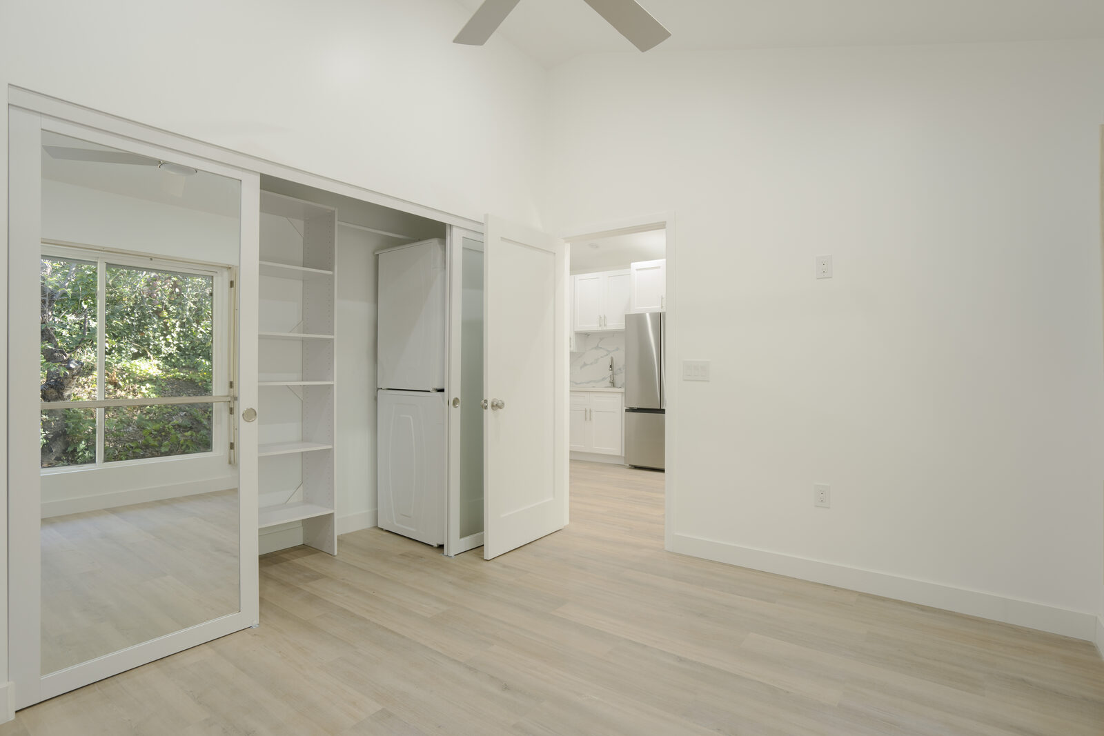 Bedroom with mirrored sliding closet doors and built-in shelving in the Thousand Oaks garage conversion ADU