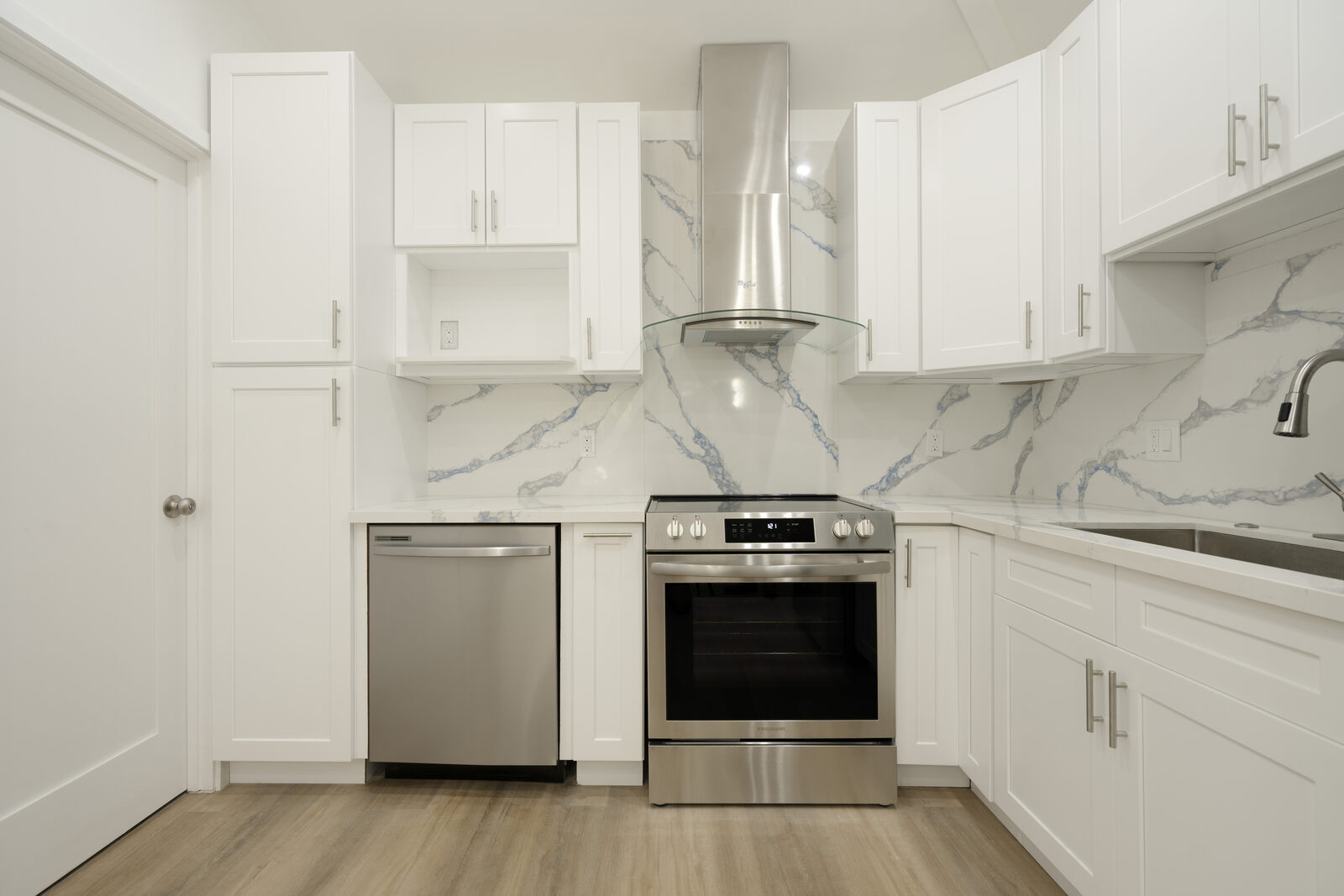 White shaker kitchen with stainless steel range and blue-veined backsplash in the Thousand Oaks ADU