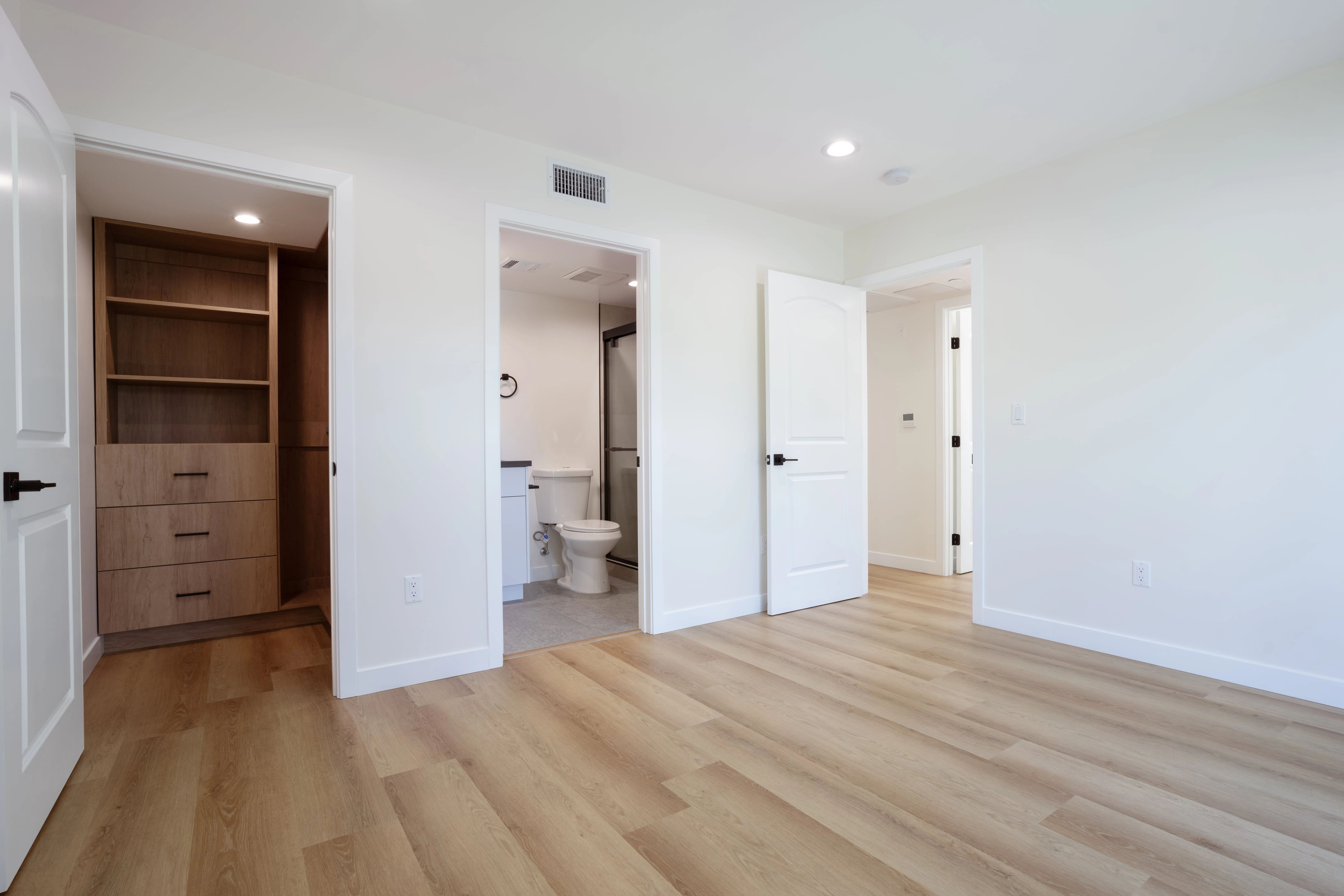 ADU bedroom with built-in closet storage, en-suite bathroom access, and modern finishes