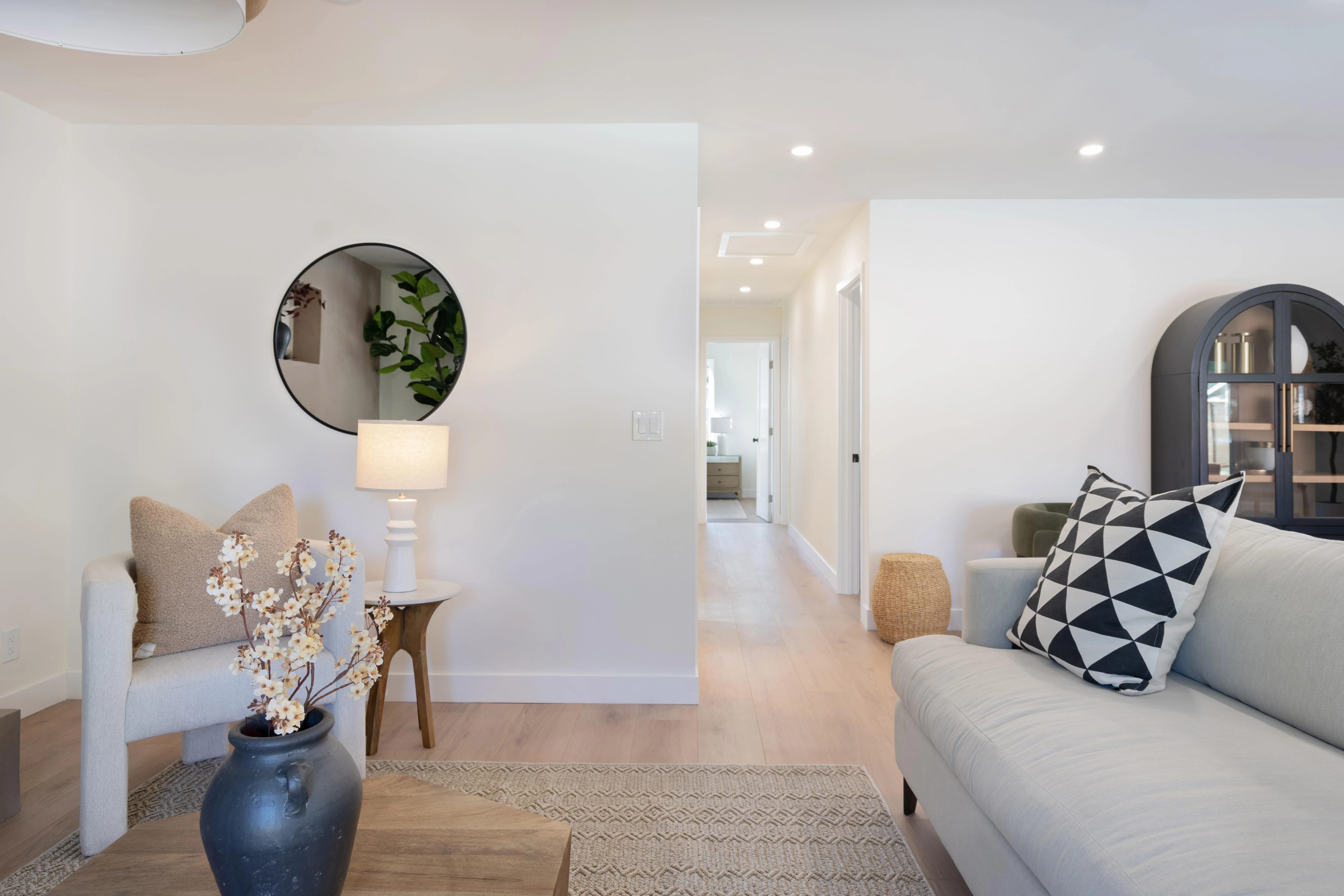 Light-filled ADU living room with modern sofa, geometric accents, and oak hardwood floors