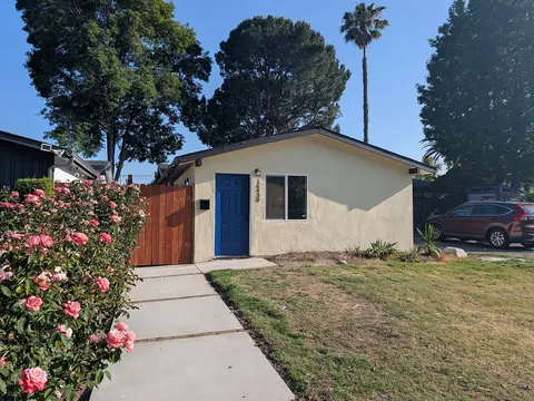 ADU with blue door, stucco exterior, and landscaped path