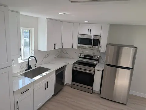 ADU kitchen with light cabinets and dark hardware