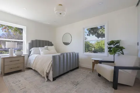 ADU bedroom with upholstered bed and daylight from windows