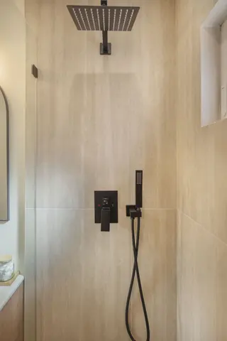 ADU rain shower with dark fixtures and glass enclosure