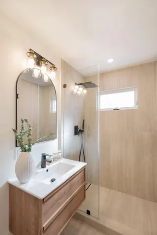 ADU bathroom with a wood vanity and glass shower