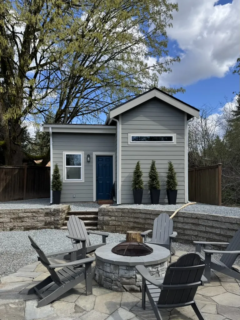 Exterior of the Kent tiny house ADU with a covered porch and fire pit